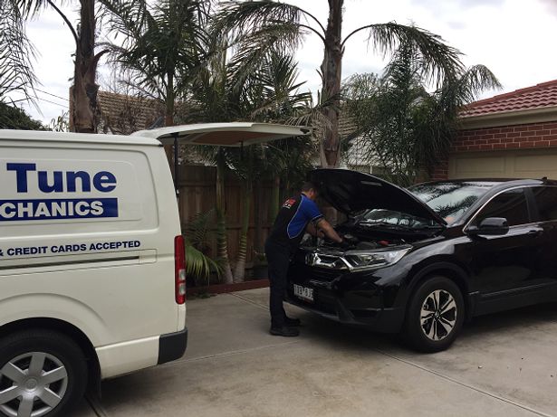 Mobile tune mobile mechanics van beside a car being fixed by a mechanic